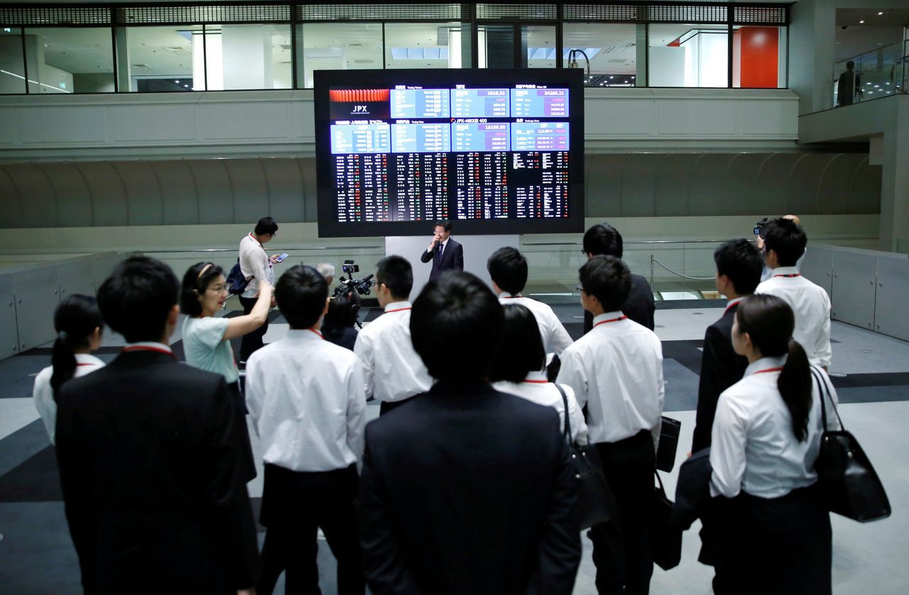 FILE PHOTO: Visitors look at an electronic stock quotation board at the Tokyo Stock Exchange (TSE) in Tokyo, Japan, October 1, 2018. REUTERS/Toru Hanai/File Photo