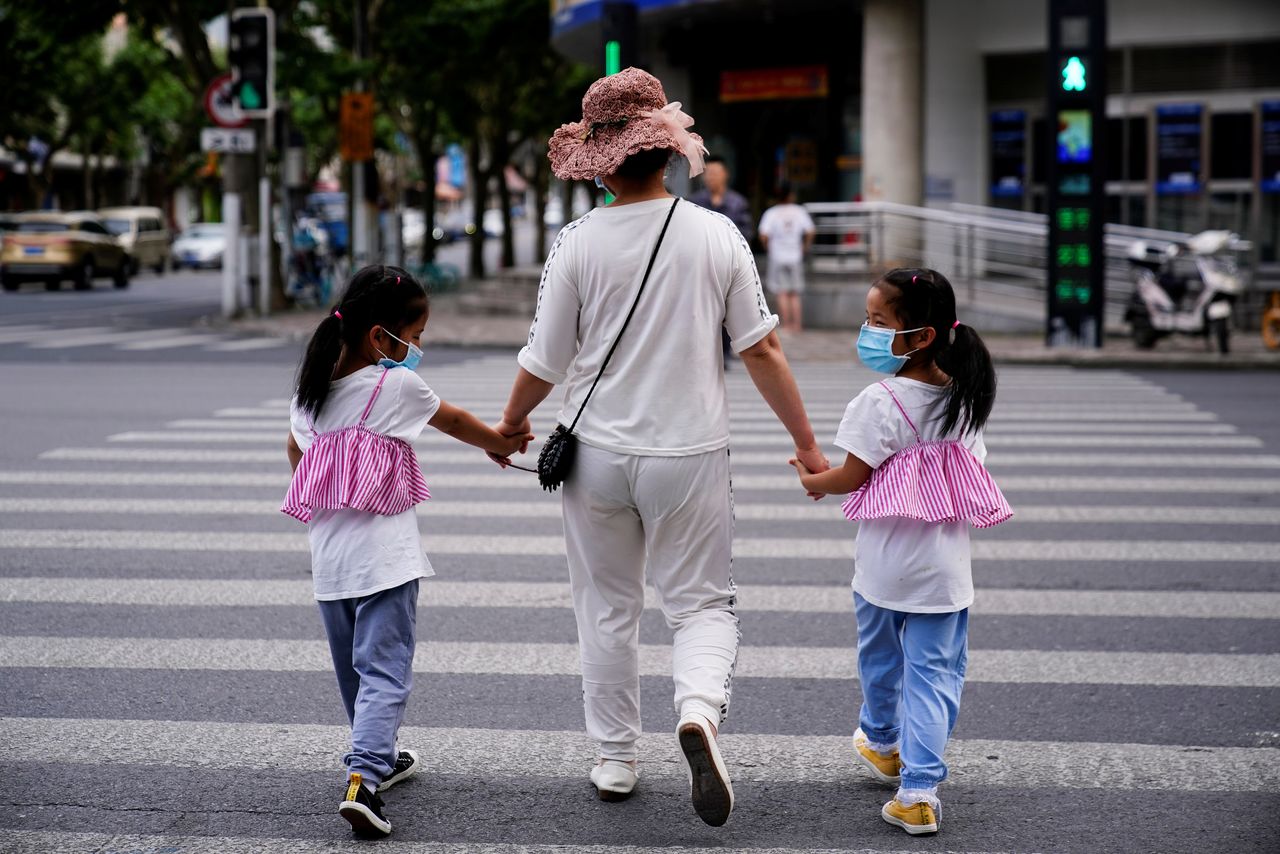 FILE PHOTO: A mother walks with her twin daughters on a street in Shanghai, China June 7, 2021. REUTERS/Aly Song