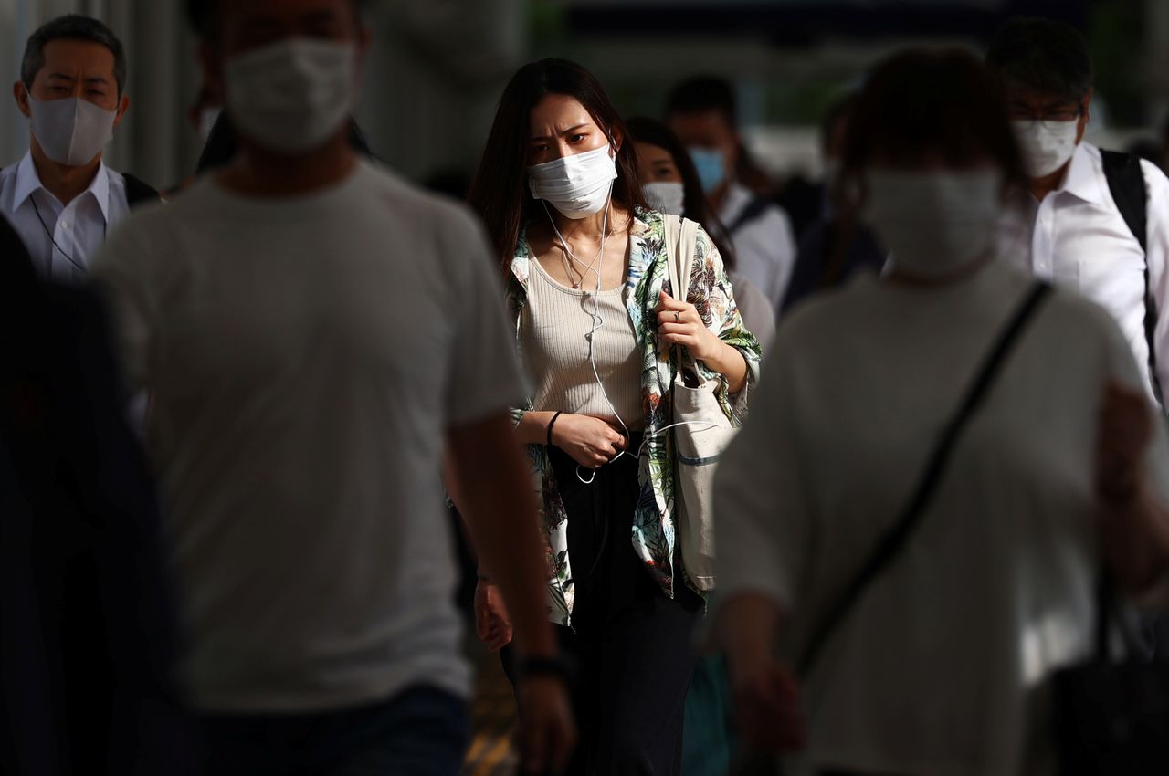 FILE PHOTO: Commuters wearing masks leave a train station during the coronavirus disease (COVID-19) outbreak in Tokyo, Japan July 16, 2021. REUTERS/Edgar Su
