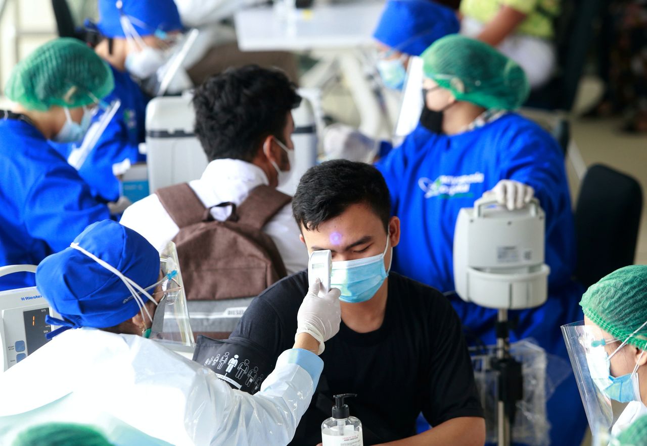 FILE PHOTO: A healthcare worker in personal protective equipment (PPE) checks a man