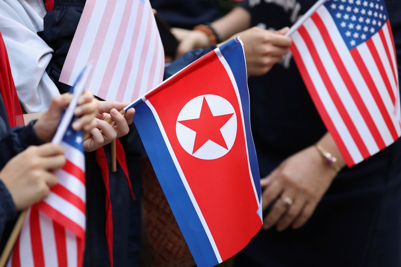 FILE PHOTO: Bystanders holding North Korea and U.S. flags wait for the motorcade of U.S. President Donald Trump in Hanoi, Vietnam, February 27, 2019. REUTERS/Ann Wang