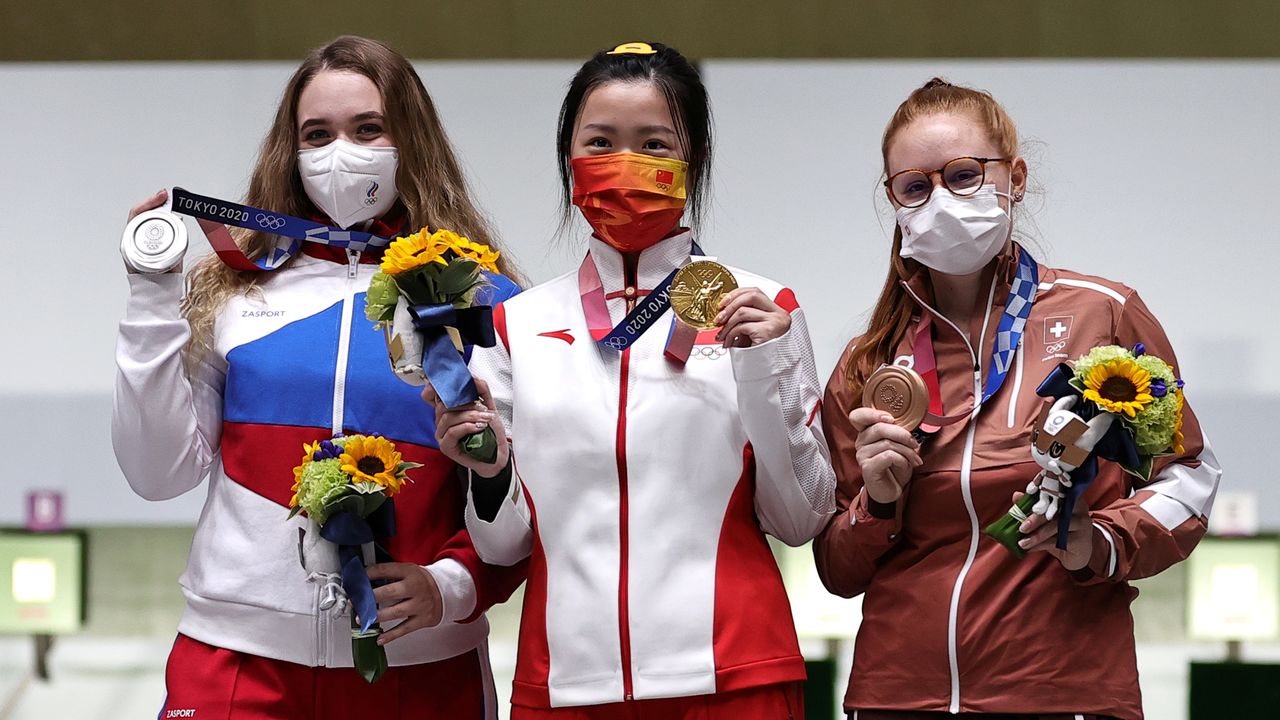 Tokyo 2020 Olympics - Shooting - Women's 10m Air Rifle - Medal Ceremony - Asaka Shooting Range, Tokyo, Japan – July 24, 2021. Gold medallist Yang Qian of China celebrates with silver medallist, Anastasiia Galashina of the Russian Olympic Committee and bronze medallist, Nina Christen of Switzerland REUTERS/Ann Wang