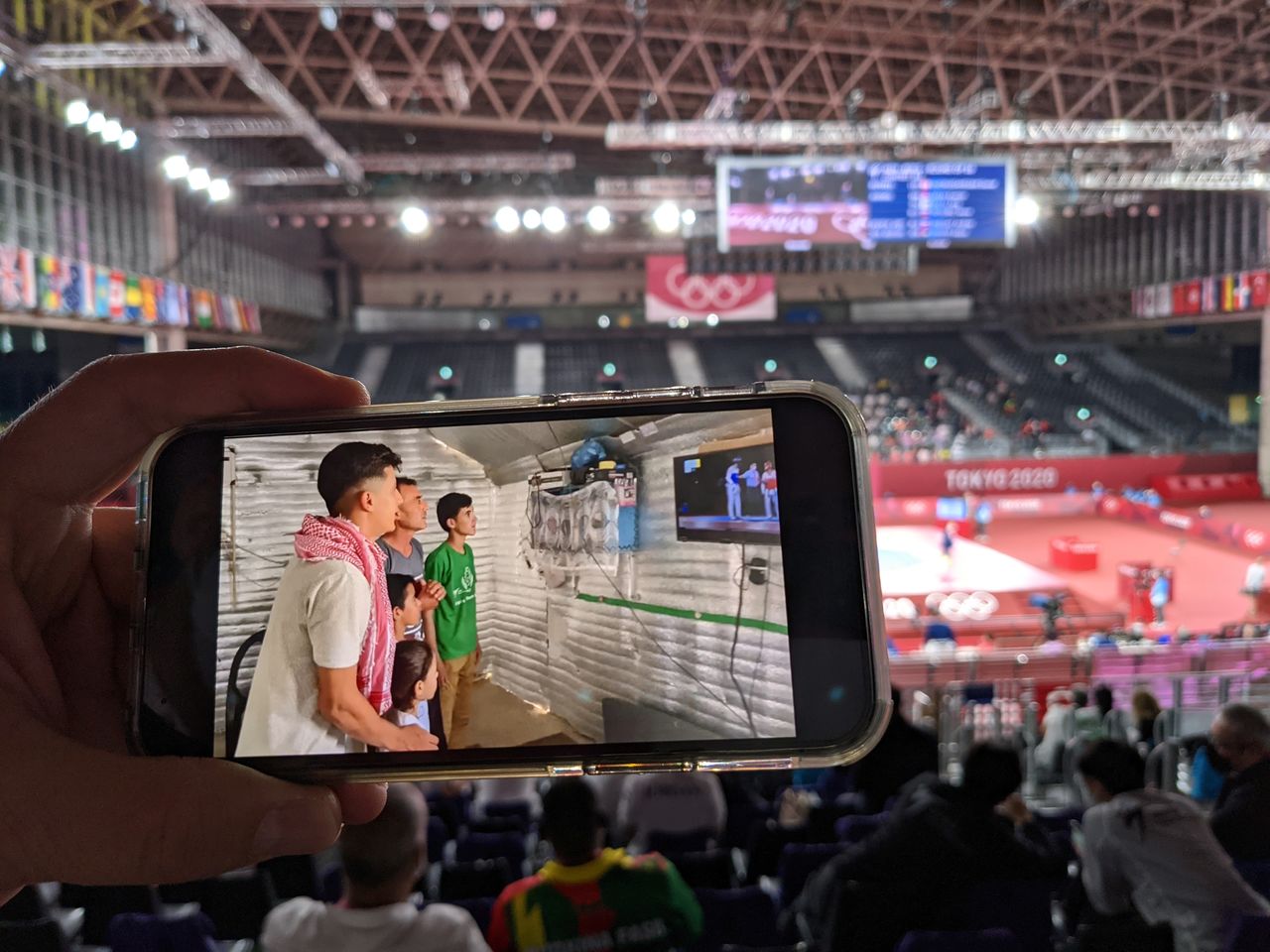 A World Taekwondo official shows a video of Syrian refugee Wael Al Faraj watching a taekwondo match on TV from Jordan's Azraq refugee camp, at an Olympic venue in Chiba, Japan, July 26, 2021. REUTERS/Chang-Ran Kim