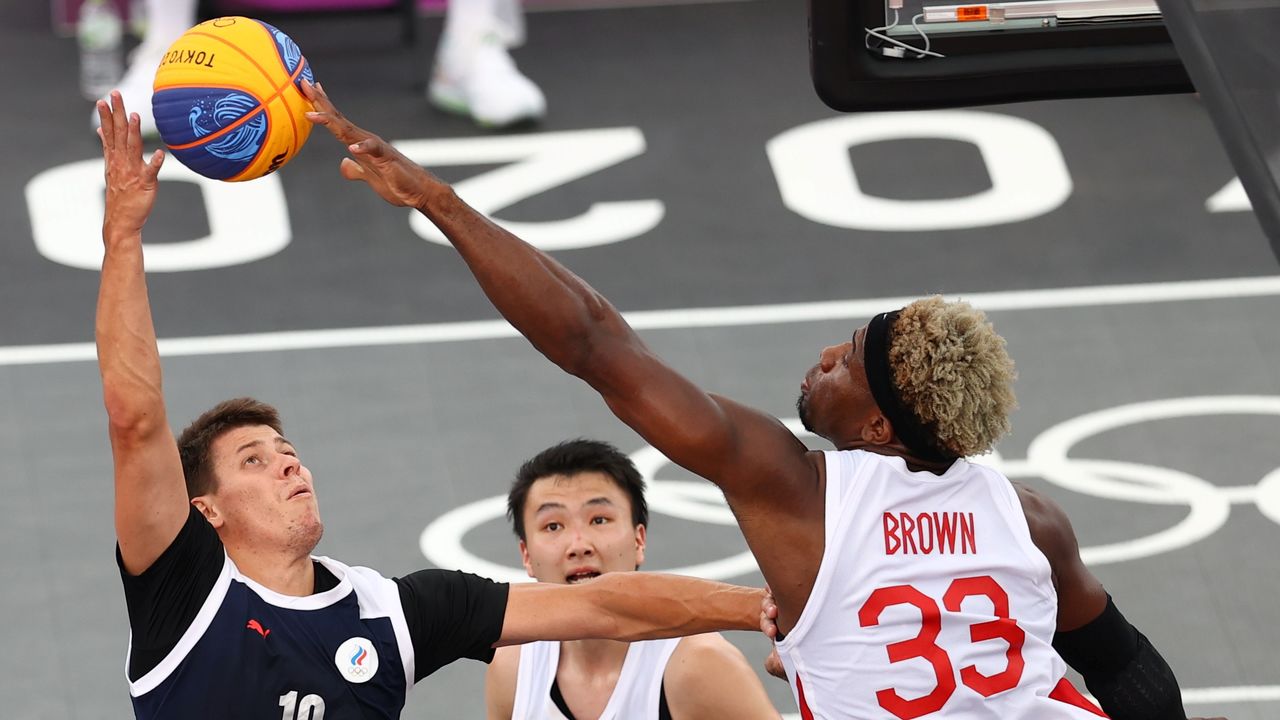 Tokyo 2020 Olympics - Basketball 3x3 - Men - Pool A - Japan v Russian Olympic Committee - Aomi Urban Sports Park, Tokyo, Japan - July 26, 2021. Ira Brown of Japan in action with Kirill Pisklov of the Russian Olympic Committee during a match. REUTERS/Andrew Boyers