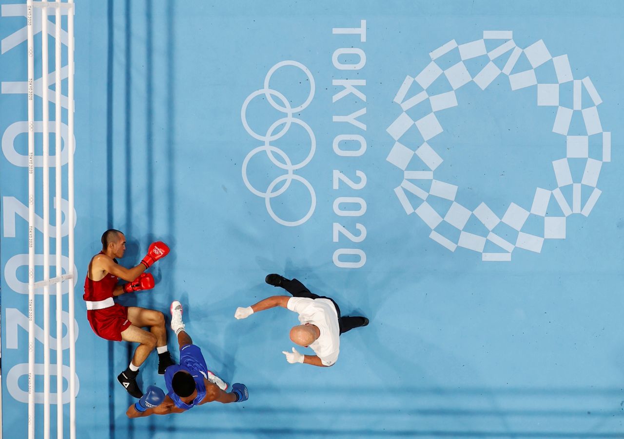 Tokyo 2020 Olympics - Boxing - Men's Middleweight - Last 32 - Kokugikan Arena - Tokyo, Japan - July 26, 2021. Eldric Sella Rodriguez of the Refugee Olympic Team lies on the ground after being knocked down during his fight against Euri Cedeno Martinez of the Dominican Republic REUTERS/Ueslei Marcelino