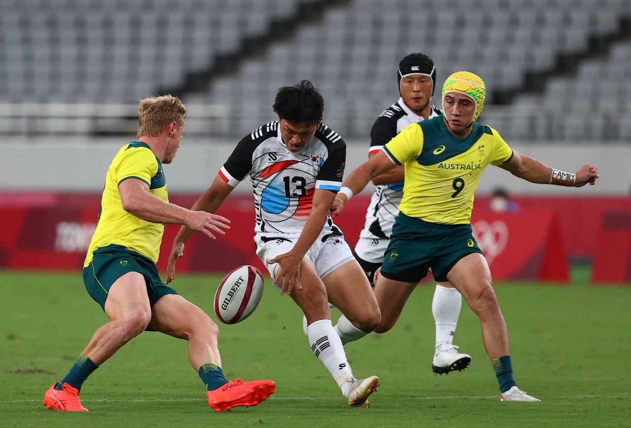 Tokyo 2020 Olympics - Rugby Sevens - Men - Pool A - Australia v South Korea - Tokyo Stadium - Tokyo, Japan - July 26, 2021. Kim Gwong Min of South Korea in action with Lachlan Miller of Australia and Josh Coward of Australia. REUTERS/Siphiwe Sibeko
