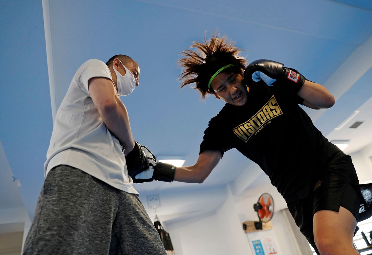 FILE PHOTO : Arisa Tsubata, a nurse and a boxer, practices with her work colleague Yuki Yamashita, a karate practitioner and the head doctor at the the Life Support psychiatric clinic, where they work, during a morning training session at the gym inside the clinic in Tokyo, Japan, April 19, 2021. REUTERS/Kim Kyung-Hoon/File Photo