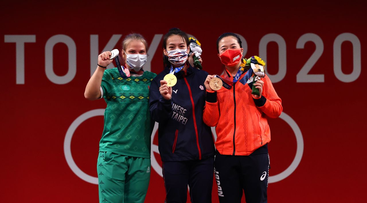 Tokyo 2020 Olympics - Weightlifting - Women's 59kg - Medal Ceremony - Tokyo International Forum, Tokyo, Japan - July 27, 2021. Gold medalist Kuo Hsing-Chun of Taiwan, silver medalist Polina Guryeva of Turkmenistan and bronze medalist Mikiko Andoh of Japan pose. REUTERS/Edgard Garrido