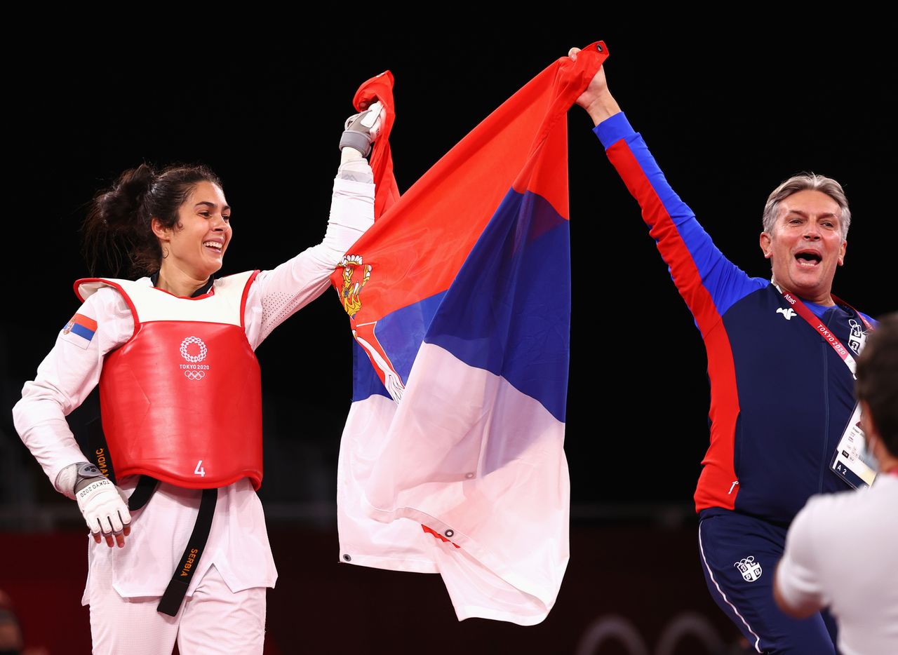 Tokyo 2020 Olympics - Taekwondo - Women's Heavyweight +67kg - Gold medal match - Makuhari Messe Hall A, Chiba, Japan - July 27, 2021. Milica Mandic of Serbia celebrates winning gold with the Serbian flag and coach REUTERS/Murad Sezer