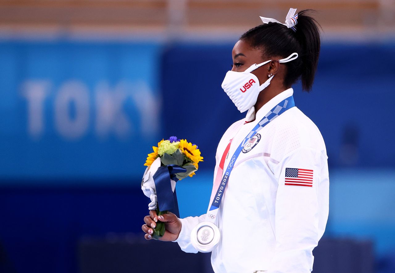 Tokyo 2020 Olympics - Gymnastics - Artistic - Women's Team - Final - Ariake Gymnastics Centre, Tokyo, Japan - July 27, 2021. Silver medallist Simone Biles of the United States wearing a protective face mask holds flowers. REUTERS/Lindsey Wasson