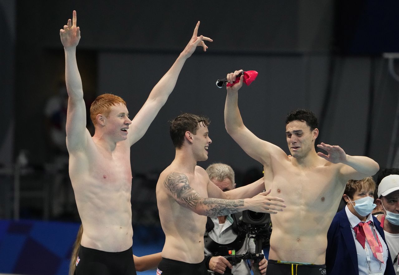 Jul 28, 2021; Tokyo, Japan; Tom Dean (GBR), James Guy (GBR) and Matthew Richards (GBR) celebrate as Great Britain wins the men's 4x200m freestyle relay during the Tokyo 2020 Olympic Summer Games at Tokyo Aquatics Centre. Mandatory Credit: Rob Schumacher-USA TODAY Sports