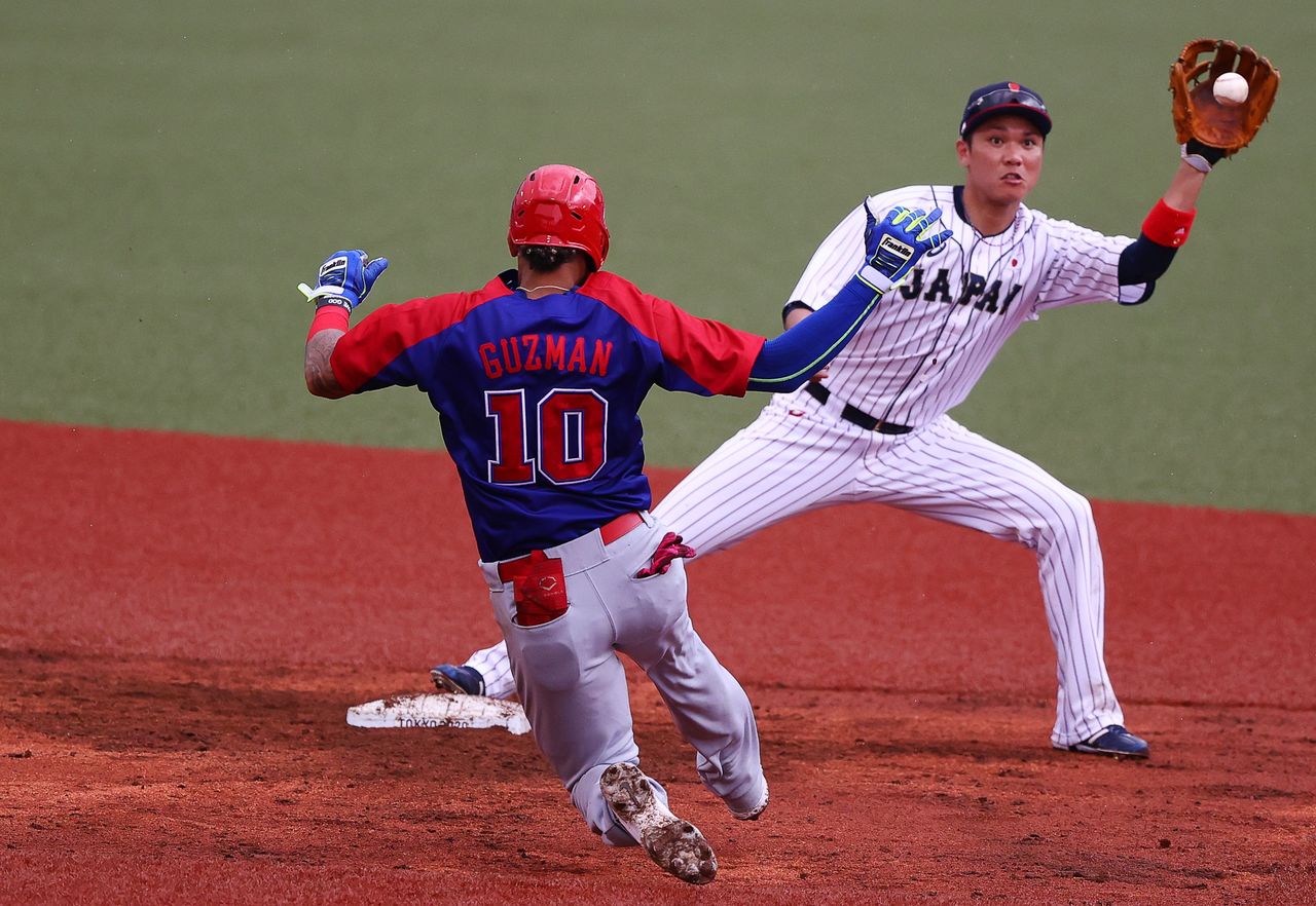Tokyo 2020 Olympics - Baseball - Men - Opening Round - Group A - Dominican Republic v Japan - Fukushima Azuma Baseball Stadium, Fukushima, Japan – July 28, 2021. Hayato Sakamoto of Japan and Jeison Guzman of the Dominican Republic in action. REUTERS/Jorge Silva