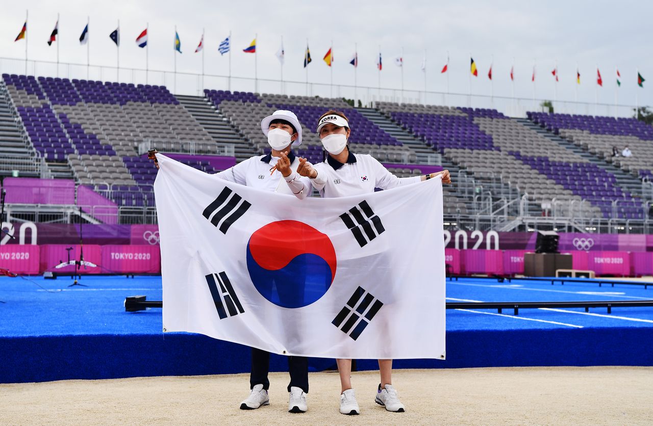 Tokyo 2020 Olympics - Archery - Women's Individual - Gold medal match - Yumenoshima Archery Field, Tokyo, Japan - July 30, 2021. An San of South Korea and her coach wave their national flag after winning gold REUTERS/Clodagh Kilcoyne
