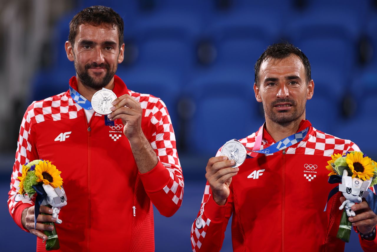 Tokyo 2020 Olympics - Tennis - Men's Doubles - Medal Ceremony- Ariake Tennis Park - Tokyo, Japan - July 30, 2021. Silver medallists Ivan Dodig of Croatia and Marin Cilic of Croatia celebrate on the podium REUTERS/Edgar Su