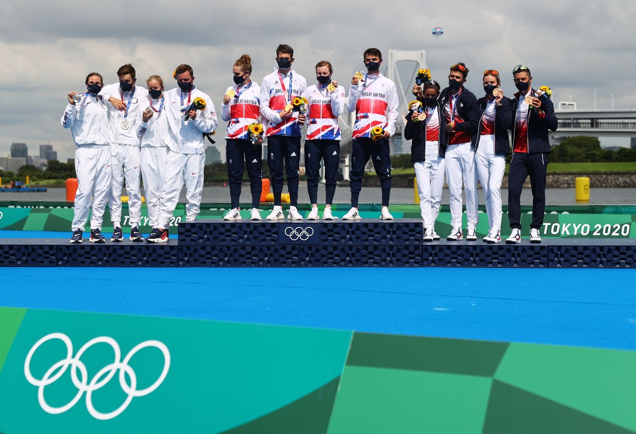 Tokyo 2020 Olympics - Triathlon - Mixed Team Relay - Medal Ceremony - Odaiba Marine Park, Tokyo, Japan - July 31, 2021. Gold medallists Jessica Learmonth of Britain, Jonathan Brownlee of Britain, Georgia Taylor-Brown of Britain and Alex Yee of Britain react on the podium with silver medallists, Katie Zaferes of the United States, Kevin McDowell of the United States, Taylor Knibb of the United States and Morgan Pearson of the United States and bronze medallists, Leonie Periault of France, Dorian Coninx of France, Cassandre Beaugrand of France and Vincent Luis of France REUTERS/Thomas Peter