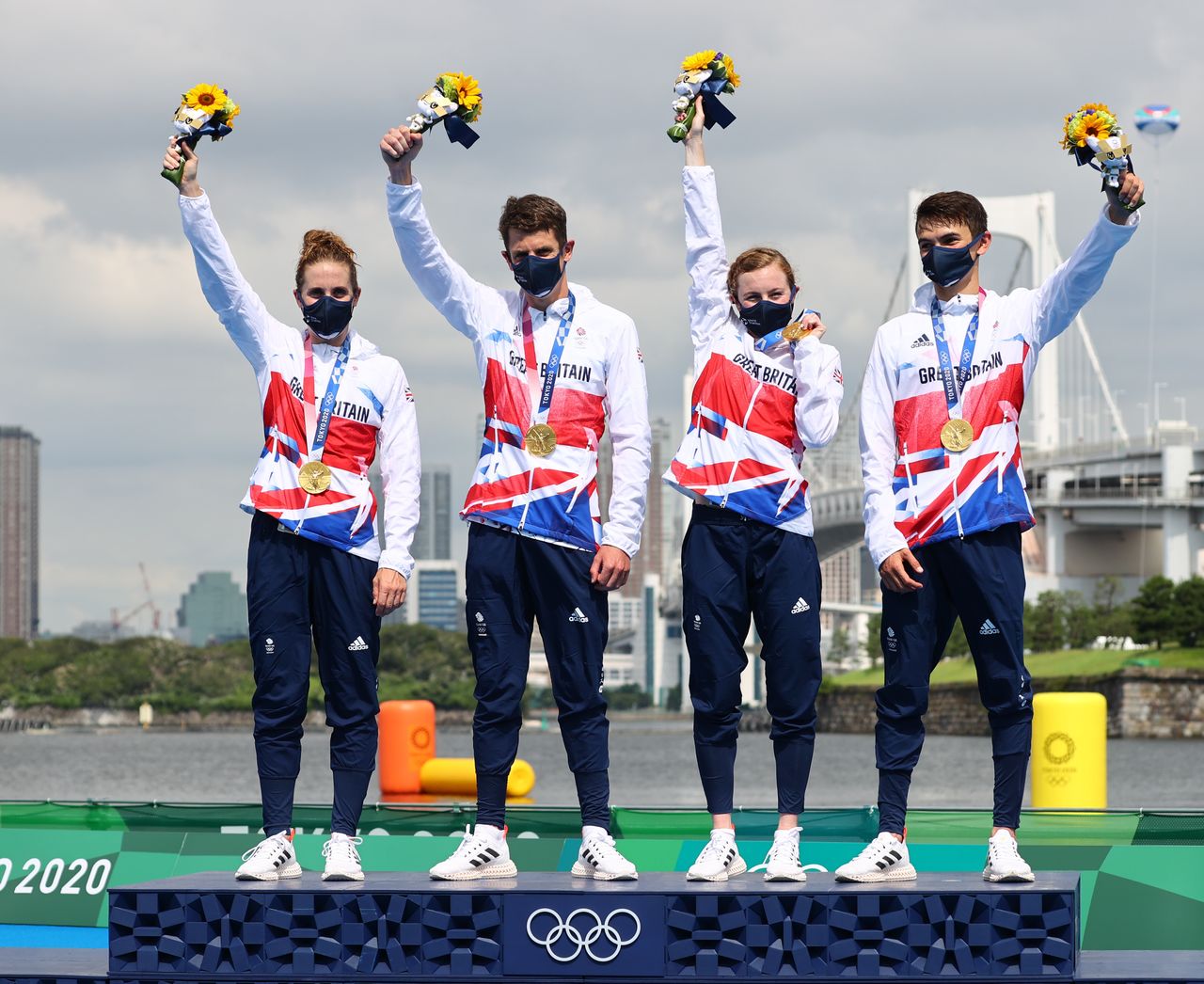 Tokyo 2020 Olympics - Triathlon - Mixed Team Relay - Medal Ceremony - Odaiba Marine Park, Tokyo, Japan - July 31, 2021. Gold medallists Jessica Learmonth of Britain, Jonathan Brownlee of Britain, Georgia Taylor-Brown of Britain and Alex Yee of Britain celebrate on the podium with masks on REUTERS/Thomas Peter