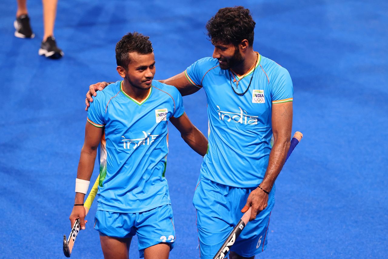 Tokyo 2020 Olympics - Hockey - Men - Quarterfinal - India v Britain - Oi Hockey Stadium, Tokyo, Japan - August 1, 2021. Vivek Prasad of India and teammate Surender Kumar of India embrace as they leave the pitch after winning their match. REUTERS/Bernadett Szabo