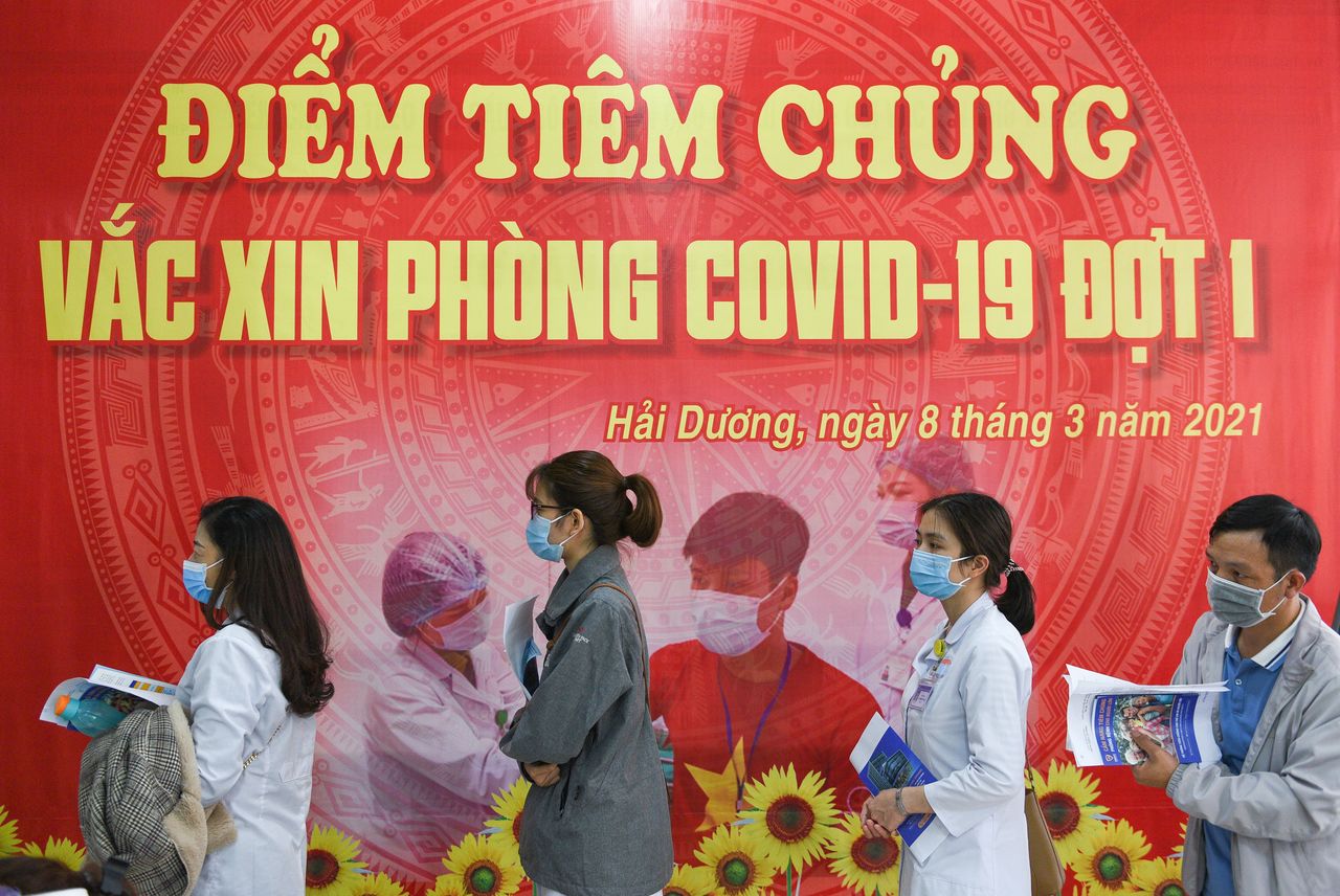 FILE PHOTO: Health workers wait for their turn as Vietnam starts its official rollout of AstraZeneca