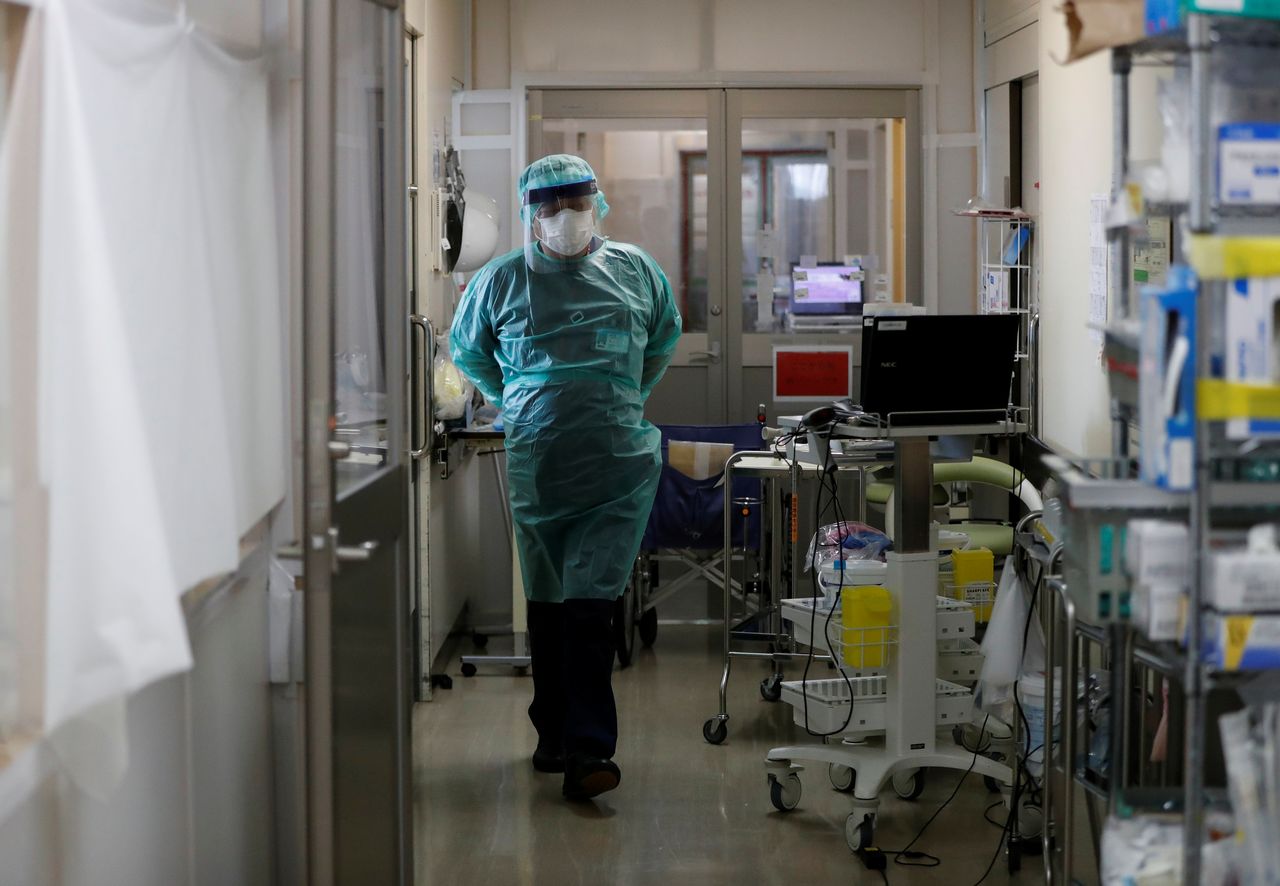 FILE PHOTO: A medical worker wearing personal protection equipment (PPE) walks inside the Intensive Care Unit (ICU) ward at St. Marianna University Yokohama Seibu Hospital where patients suffering from the coronavirus disease (COVID-19) are being treated in Yokohama, south of Tokyo, Japan May 25, 2021. REUTERS/Issei Kato