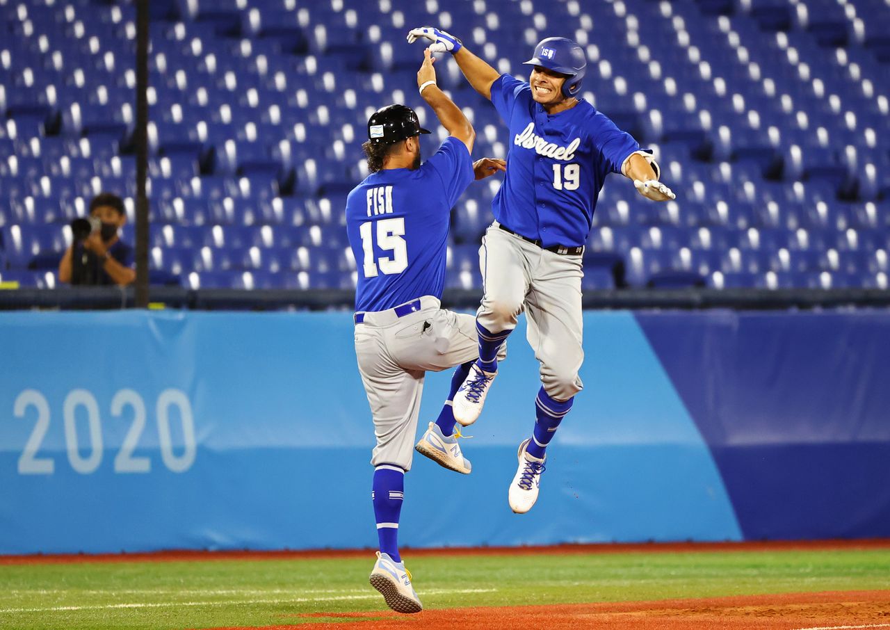 Tokyo 2020 Olympics - Baseball - Men - Round 1 Repechage - Israel v Dominican Republic - Yokohama Baseball Stadium, Yokohama, Japan - August 3, 2021. Danny Valencia of Israel celebrates home run with coach Nate Fish. REUTERS/Jorge Silva