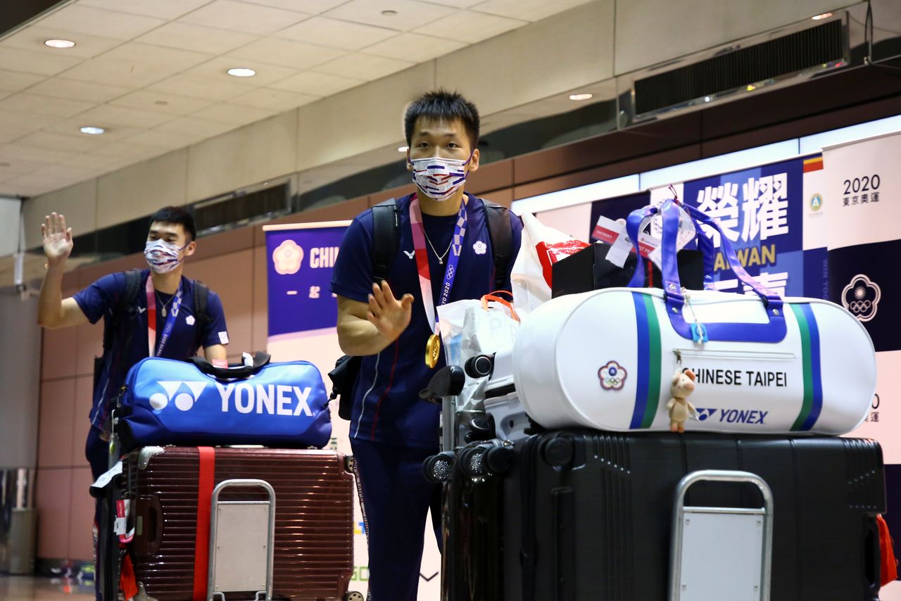 Gold medallists Wang Chi-Lin and Lee Yang wave at supporters as they arrive at Taoyuan International Airport following their return from the Tokyo Olympic Games in Taoyuan, Taiwan, August 4, 2021. REUTERS/Annabelle Chih
