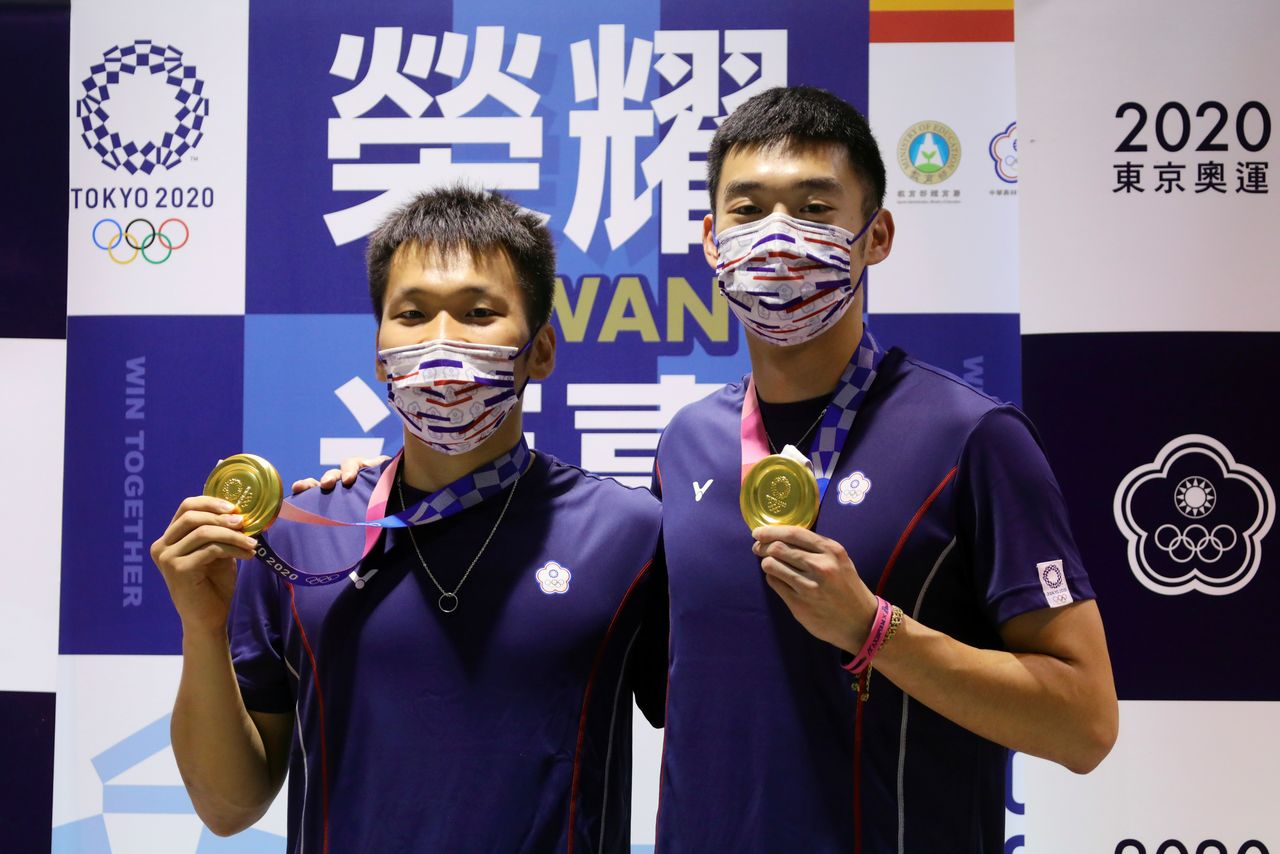 Gold medallists Wang Chi-Lin and Lee Yang pose with their medals at Taoyuan International Airport following their return from the Tokyo Olympic Games in Taoyuan, Taiwan, August 4, 2021. REUTERS/Annabelle Chih