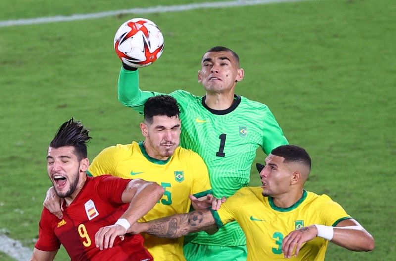 Tokyo 2020 Olympics - Soccer Football - Men - Gold medal match - Brazil v Spain - International Stadium Yokohama, Yokohama, Japan - August 7, 2021. Santos of Brazil punches clear of Nino of Brazil, Diego Carlos of Brazil and Rafa Mir of Spain. REUTERS/Stoyan Nenov