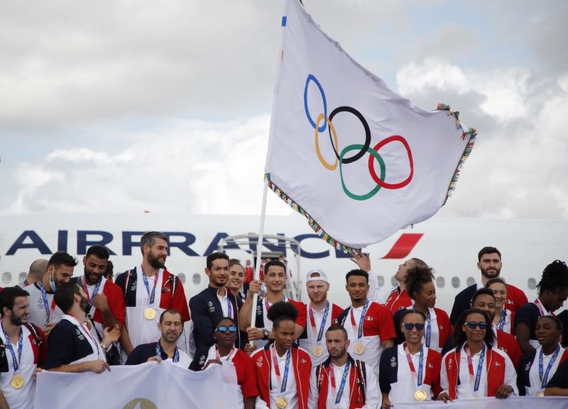 Olympics - French Olympic medallists arrive with the Olympic flag in Paris - Roissy Charles de Gaulle airport, Paris, France - August 9, 2021 French handball players and french Olympic medallists pose with their medals and the Olympic flag as they arrive at Roissy Charles de Gaulle airport REUTERS/Sarah Meyssonnier