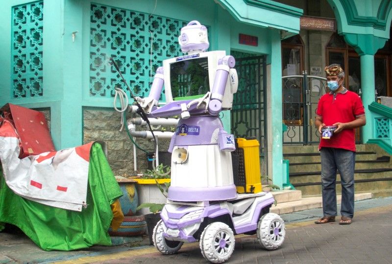 Aseyanto, 53, a resident of the Tembok Gede neighbourhood, operates the "Delta Robot", made from household items like pots, pans and an old television monitor, in Surabaya, East Java province, Indonesia, August 7, 2021. The robot is able to perform a number of tasks such as spraying disinfectant, delivering food and meeting the needs of residents who are are self-isolating due to coronavirus disease (COVID-19). Picture taken August 7, 2021. REUTERS/Prasto Wardoyo