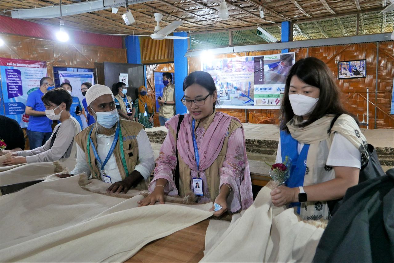 Nacken Ritsu (right) at a jute product center where refugees learn how to make clothes, bags, and other products from jute. (© UNHCR/Tiy Chung)