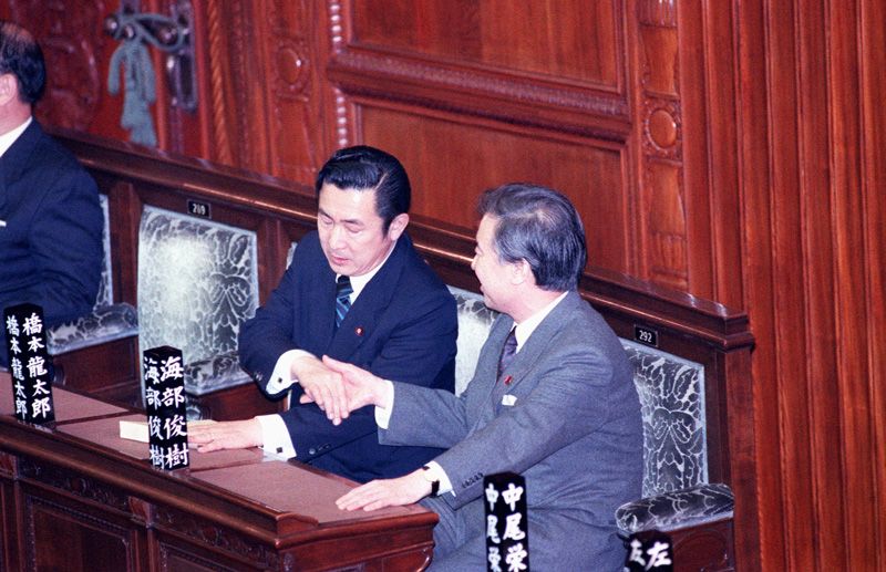 El primer ministro Kaifu Toshiki y el ministro de Finanzas Hashimoto Ryūtarō se saludan<br>después de la aprobación de un proyecto de ley que contemplaba una ayuda adicional de nueve mil millones de dólares a la coalición internacional (28 de febrero de 1991). Foto: Jiji Press, Ltd.