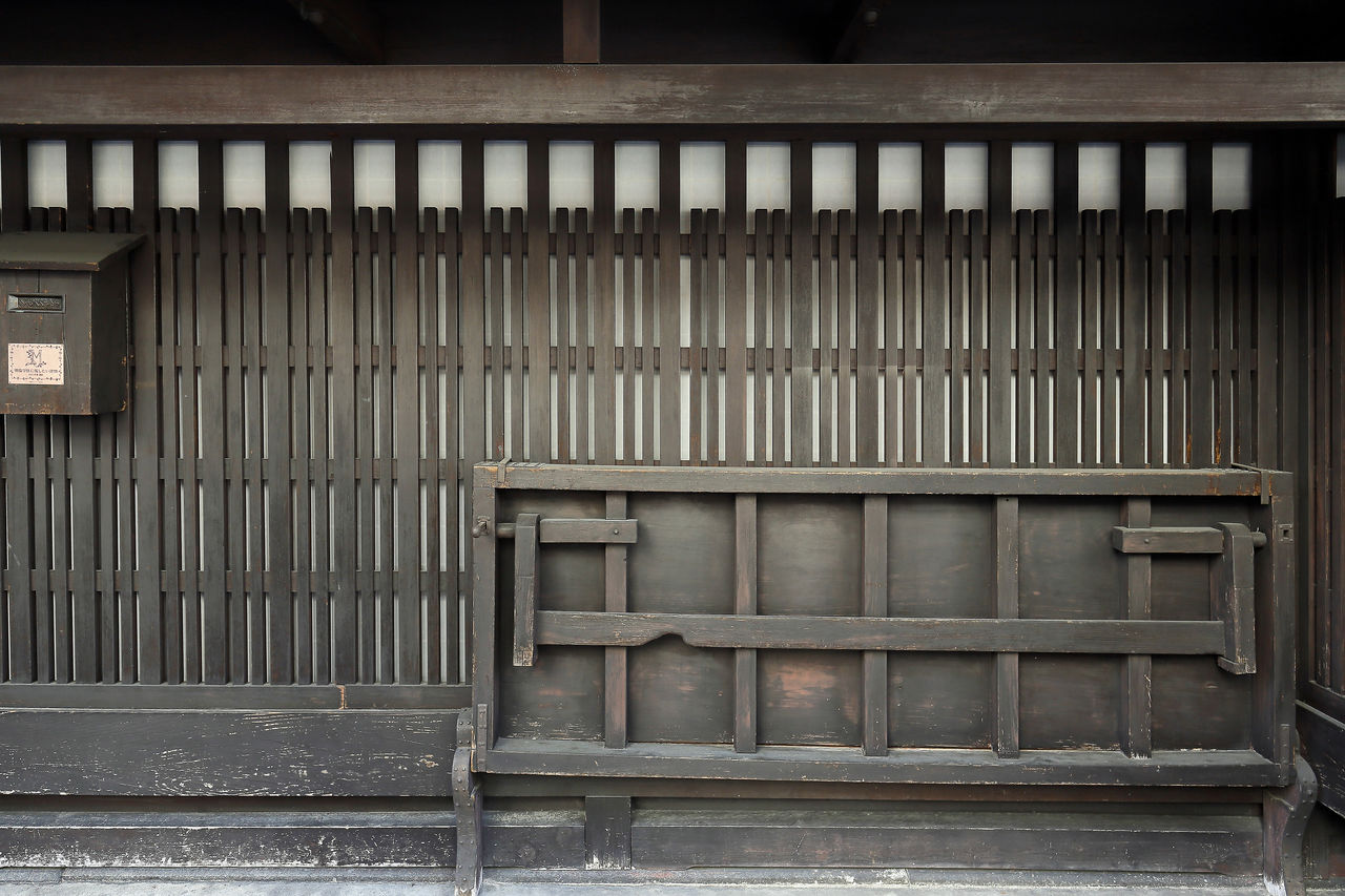 Una machiya con rejas itoya y una mesa plegable battari shōgi (derecha). La reja no llega al techo para que la luz del sol pueda pasar. 