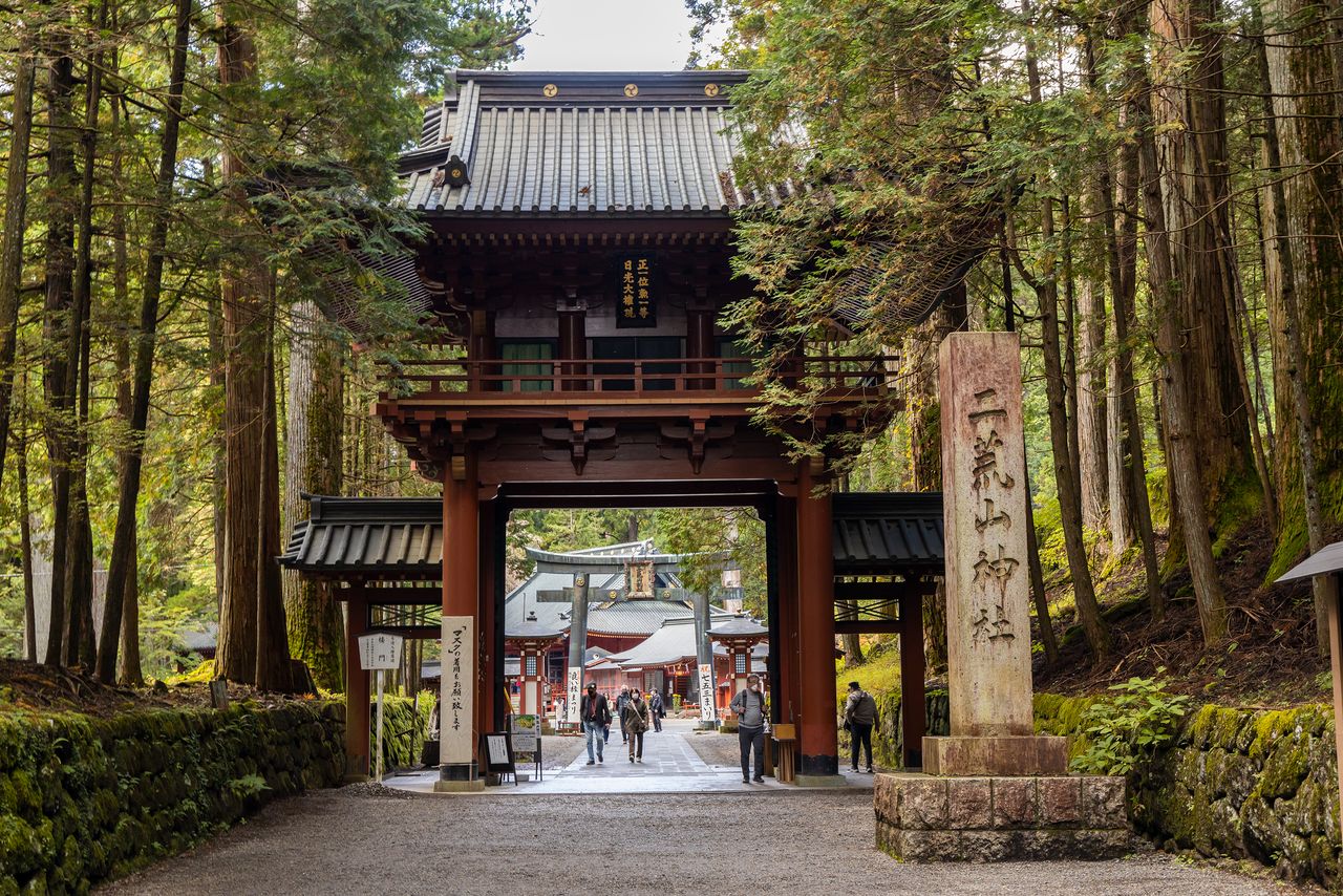 La puerta Rōmon, en la entrada desde Kamishinmichi, acceso al santuario que se extiende desde el santuario de Nikkō Tōshōgū. Al fondo se puede observar el pórtico torii Karadō, Patrimonio de la Humanidad.