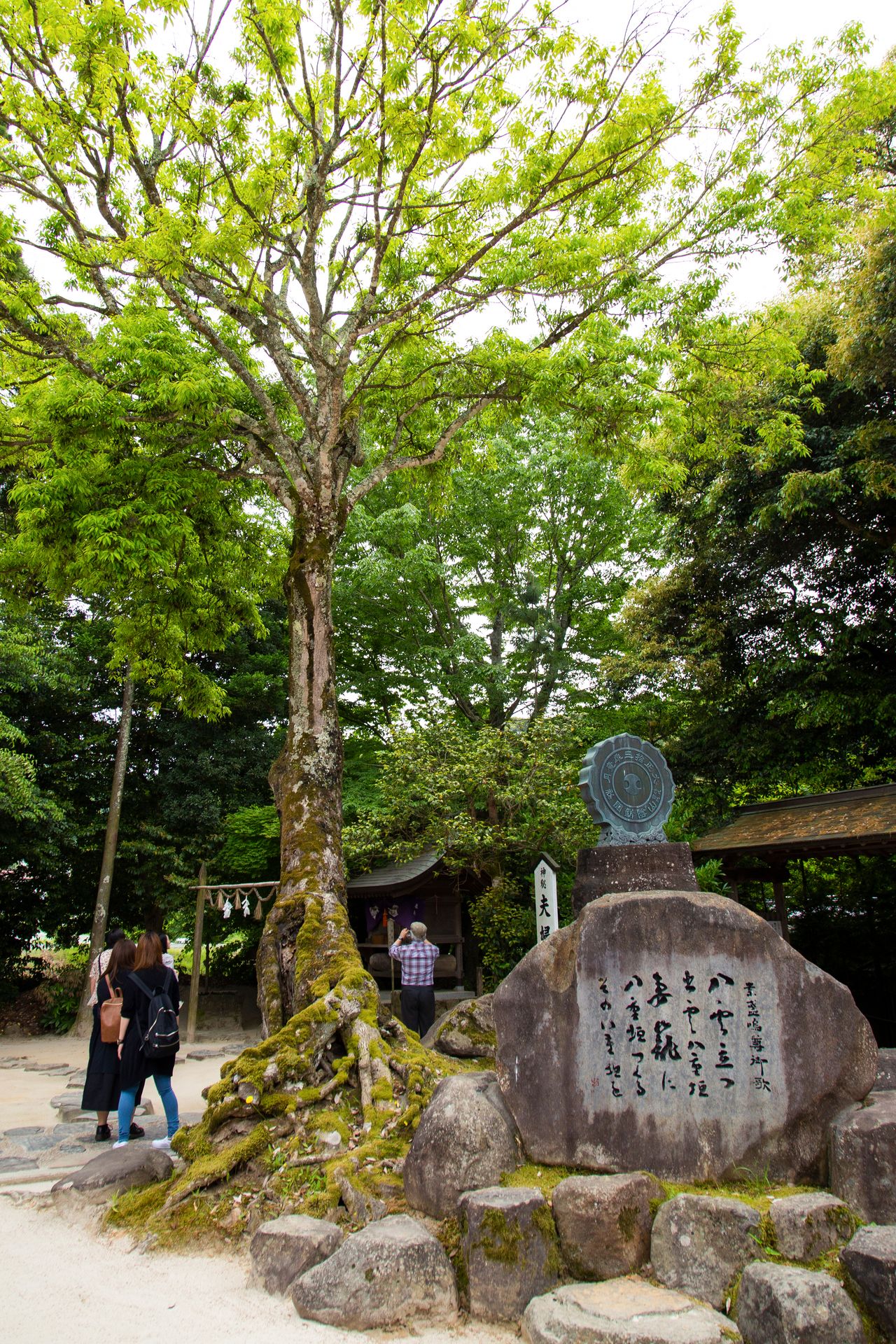 Monumento de piedra con el waka más antiguo de todo Japón, a la izquierda del haiden o capilla del santuario.