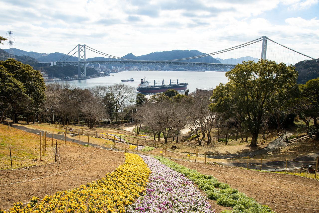 Se puede ver el estrecho de Kanmon desde el Parque Hinoyama. La orilla del otro lado del estrecho, frente a Dannoura-chō, es la zona de Mekari, en el distrito de Moji de la ciudad de Kitakyūshū. La distancia entre los dos lugares es de 700 metros.