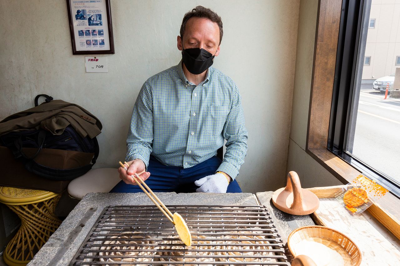 Un miembro de la sección de inglés de nippon.com asando su propia senbei. Voltear la galleta cada tres segundos es una tarea bastante ardua.