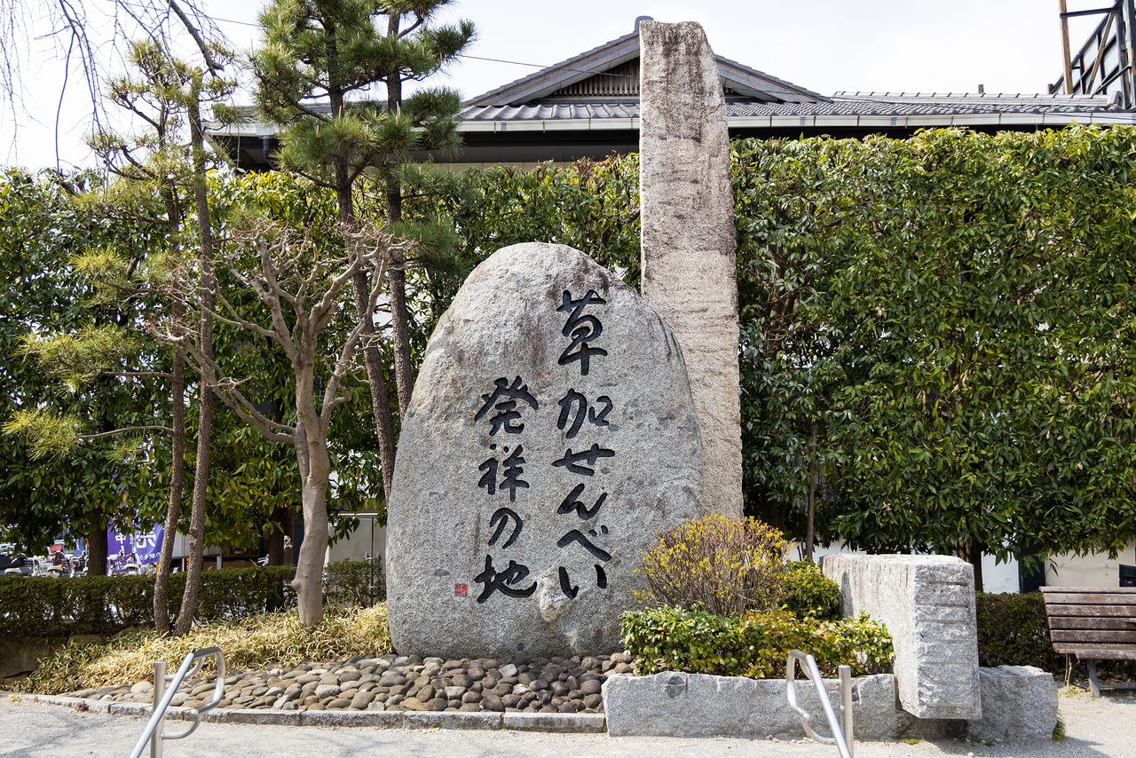 El monumento de piedra conmemorativo del lugar de origen de la Sōka Senbei en el parque Osen.