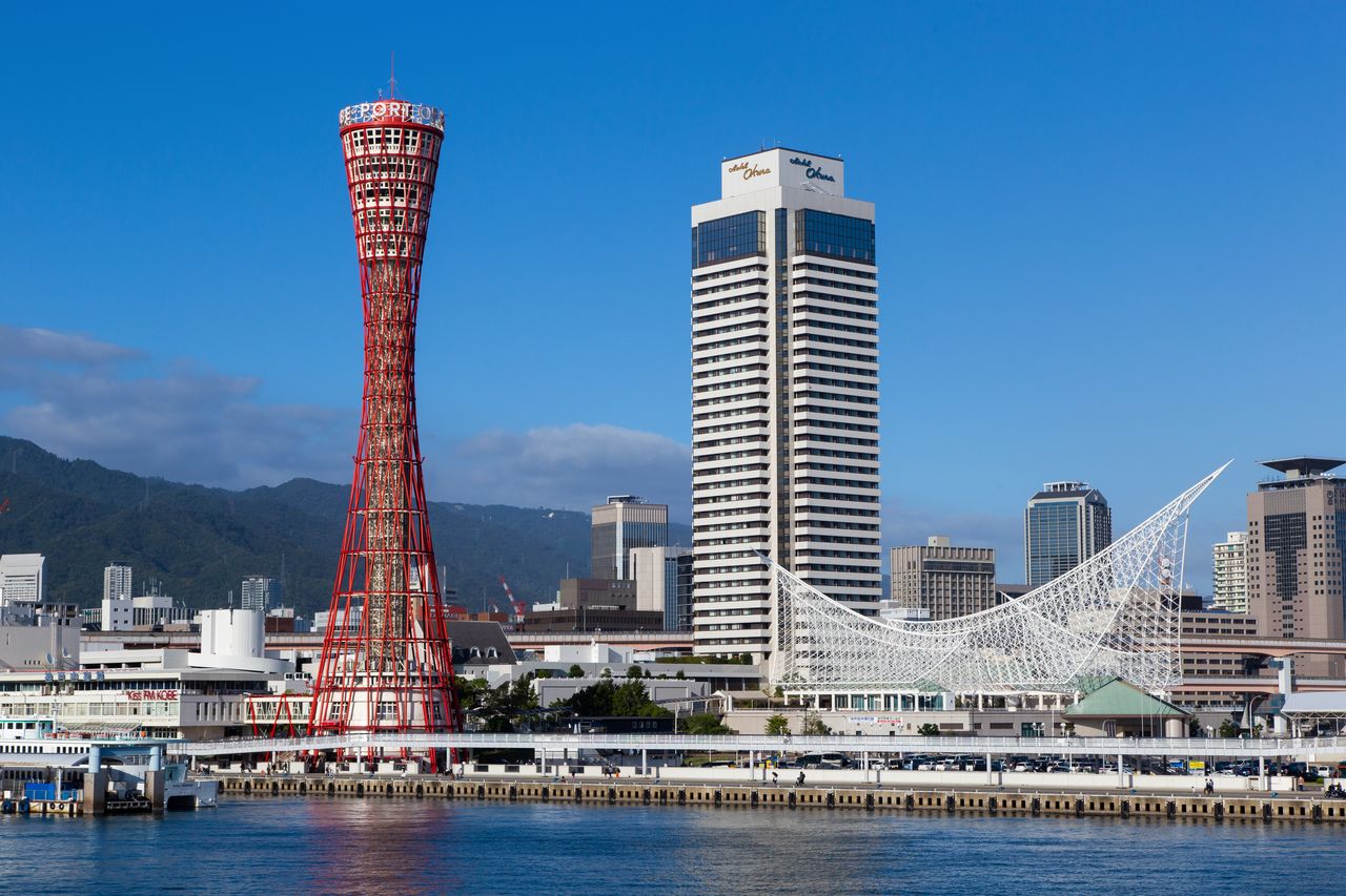 La torre roja del puerto de Kobe (a la izquierda), un punto de referencia local; el Museo Marítimo de Kobe (a la derecha), con su techo arqueado, cuya forma recuerda a un barco cruzando las olas. 