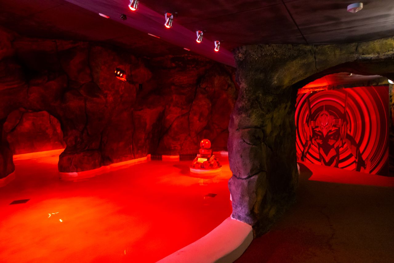 La terma de aguas rojas dentro de la cueva se ilumina para crear una atmósfera más misteriosa.