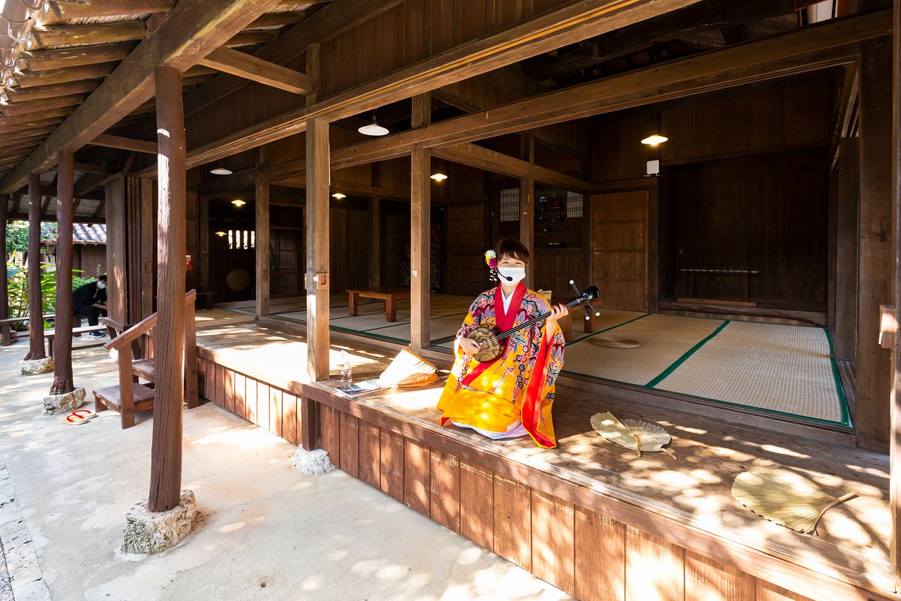 El visitante puede entrar en la casa y probar a tocar el instrumento de cuerdas sanshin.