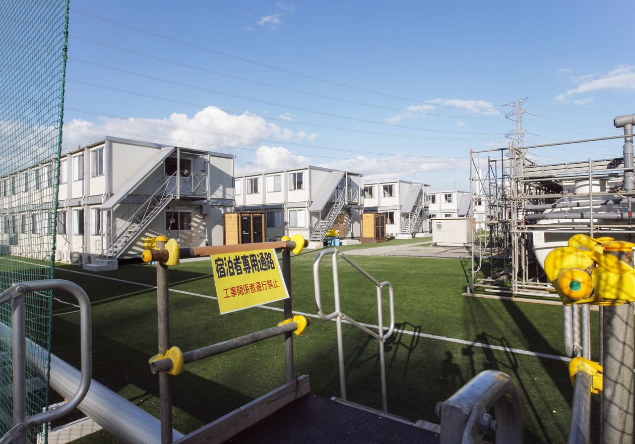 Viviendas provisionales construidas por TEPCO cubren uno de los campos del Centro Nacional de Entrenamientos J-Village. (Fotografía de septiembre de 2011, Jiji Press)