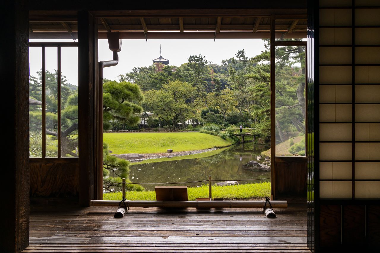 Vistas desde la sala Tsugi-no-Ma del tercer edificio del Rinshunkaku. La pagoda de tres pisos, símbolo del Sankeien, armoniza hermosamente con el estanque y las flores.