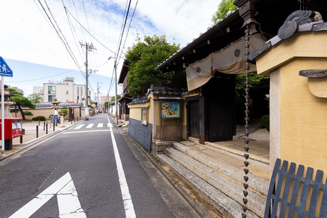 Frente al museo (derecha) se encuentra la puerta principal del templo de Mibu detrás de un buzón rojo.
