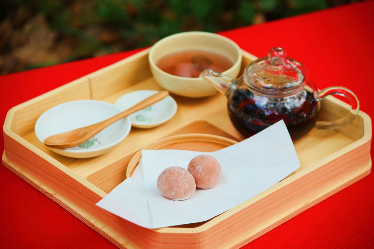Dulce sarumochi y té caliente de sojas. Después de disfrutar del té se pueden sacar las sojas negras de la tetera y comerlas con sal.
