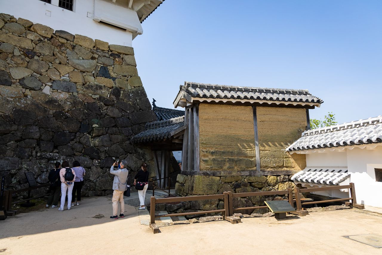A la izquierda la piedra ubagaishi en la base del muro del torreón, a la derecha, la pared de adobe yūheki que data de los tiempos de Hashiba.