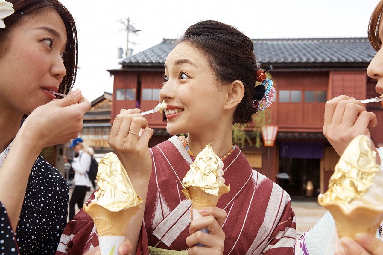Turistas estivales disfrutan de un helado decorado con pan de oro en Kanazawa. (© Pixta)
