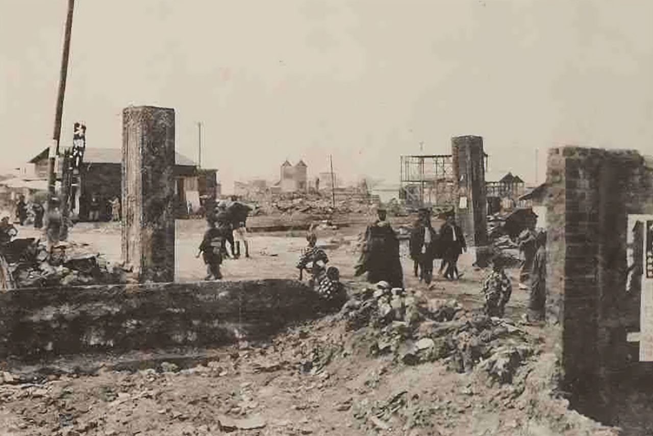 Cercanías de la Puerta principal de Yoshiwara una vez retirada la mayor parte de los escombros. Al fondo, a la izquierda, puede verse ya abierto un bar llamado Hongō. Imagen del álbum fotográfico Tōkyō shinsai-roku (“Registro del gran terremoto de Tokio”), publicado en 1926. (Colección de la Biblioteca Central Metropolitana de Tokio)