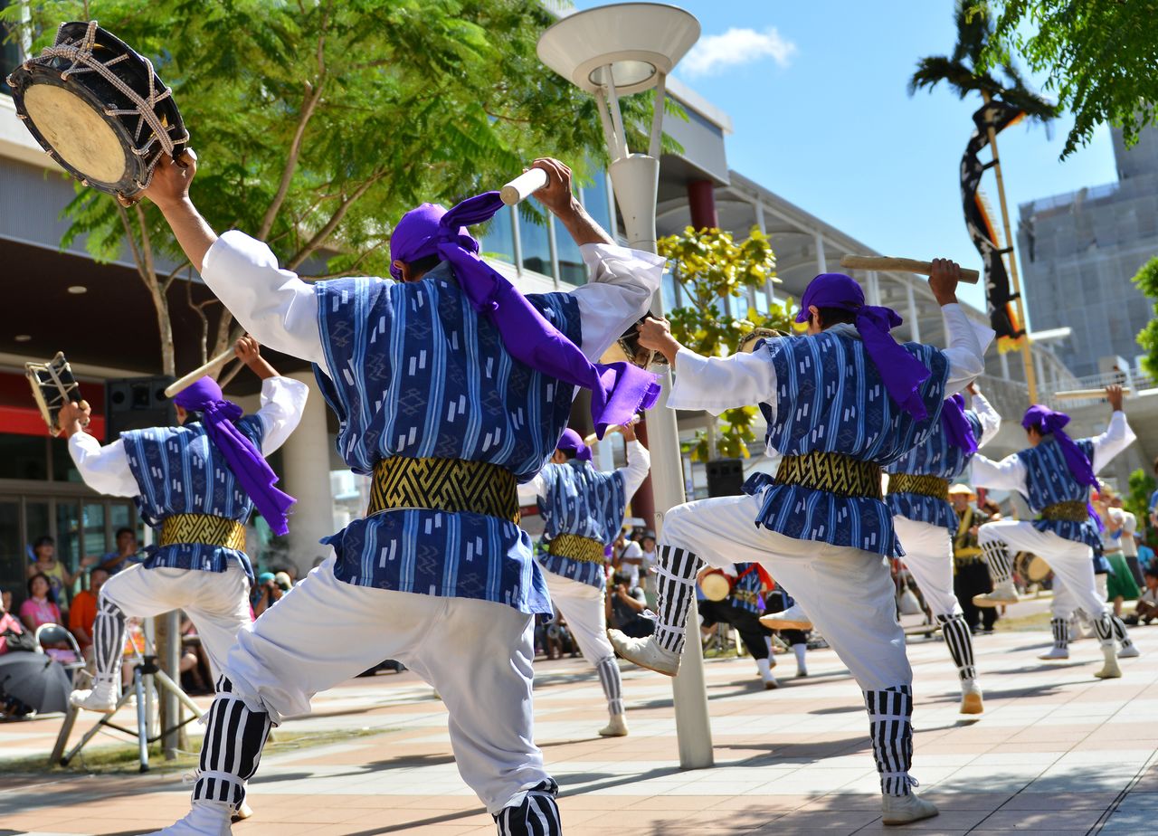 Varios hombres tocan el tambor mientras ejecutan la danza tradicional eisā de Okinawa. (© Pixta)