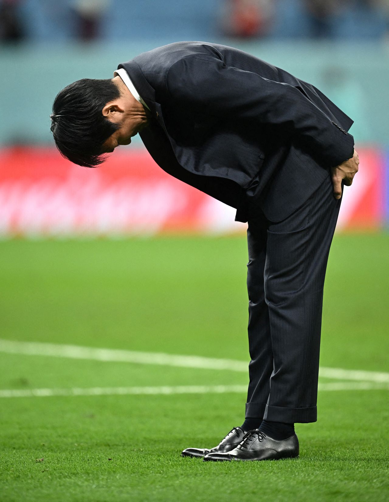 El entrenador Moriyasu Hajime hace una profunda reverencia ante los aficionados en las gradas, después de que Japón fuera eliminado de la final del Mundial de Qatar. El 5 de diciembre de 2022. (Reuters)