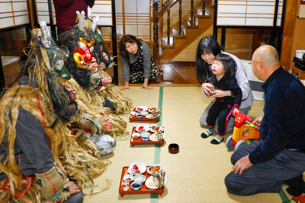 Ofreciendo comida y bebida a los namahage que han venido a casa a traer buena fortuna.